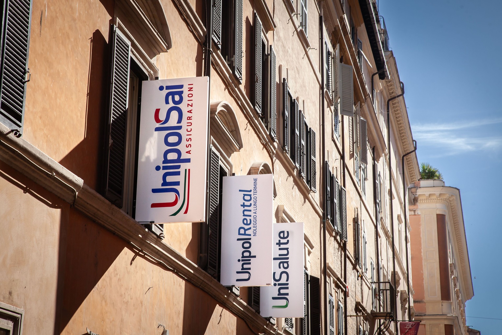 Unipol insurance logos including UnipolSai, UnipolRental, and UniSalute on an office building in Rome, Italy. unipol is one of the main italian insurance groups.