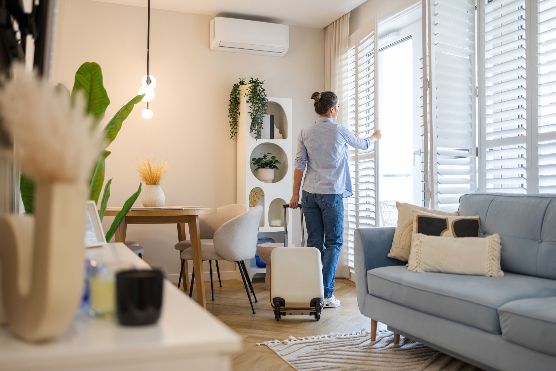 Young woman with her suitcase in a rented apartment