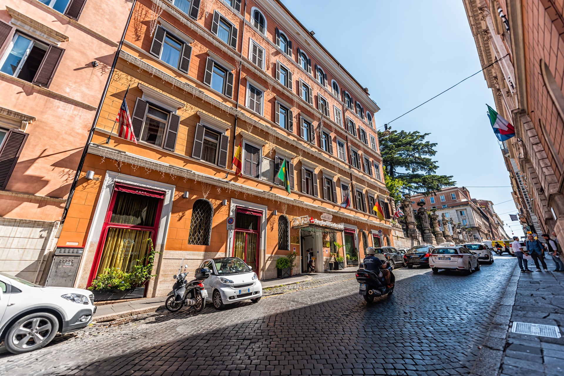 City town Via delle Quattro Fontane street by Hotel Anglo Americano with sign and flags wide angle view